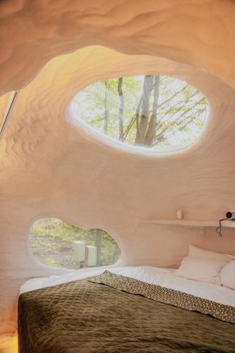 a bedroom with a bed with a round window at Serenity Lodge in Dragomirna
