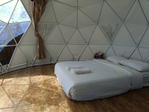 a bedroom with a large white bed in a tent at ภูแสงไฟโฮมสเตย์ in Ban Tai