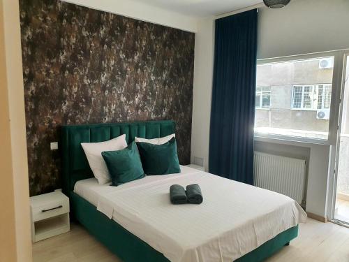 ein Schlafzimmer mit einem Bett mit zwei Schuhen drauf in der Unterkunft Edgar Apartment in Bukarest