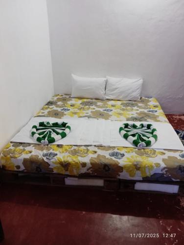 a bed with a floral comforter on top of it at Nimal's white house in Nilaveli