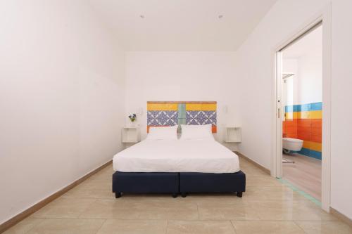 a white bedroom with a bed and a bathroom at Aequa Hotel in Vico Equense