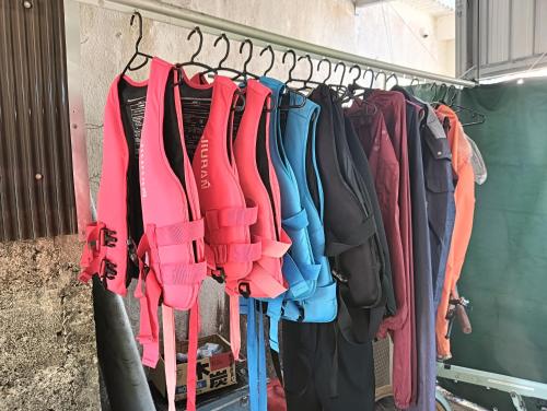 a bunch of clothes are hanging on a rack at Holiday House Ryukyu-an "MUSIC HOSTEL" in Yomitan