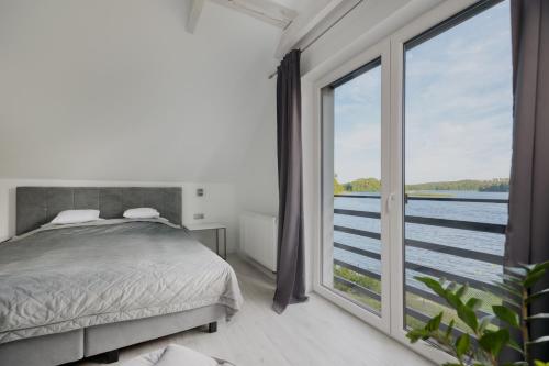 a bedroom with a bed and a large window at Trzy Wyspy Barlinek in Barlinek