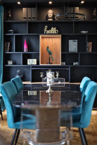 a dining room with a glass table and blue chairs at Le Versailles Suite classé 3 étoiles Vue Château & Potager in Versailles