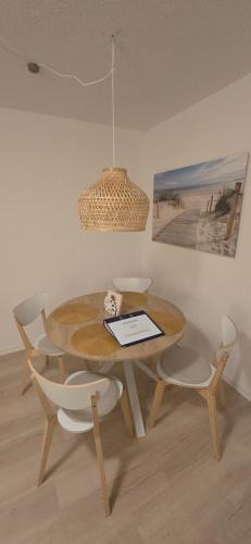 a dining room table with chairs and a tablet on it at Ferienwohnung Horsti in Timmendorfer Strand