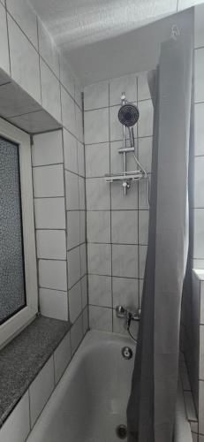 a bathroom with a bath tub with a shower at Ferienwohnung Horsti in Timmendorfer Strand