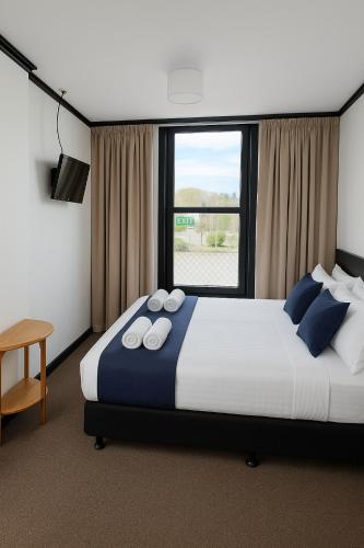 a bedroom with a large bed and a window at The Old Railway Hotel Lumsden in Lumsden