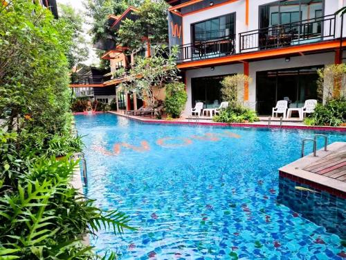 a swimming pool in front of a building at WOW PHUKET in Phuket Town