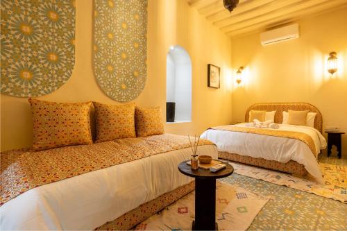 - une chambre avec 2 lits et une table dans l'établissement Riad Dar Tiflet, à Marrakech