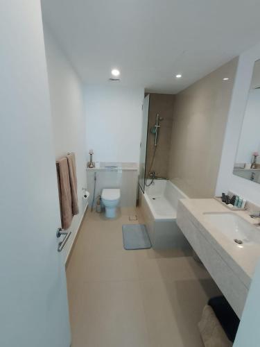 a white bathroom with two sinks and a toilet at Dubai Hills Mahek Holiday Villa in Dubai