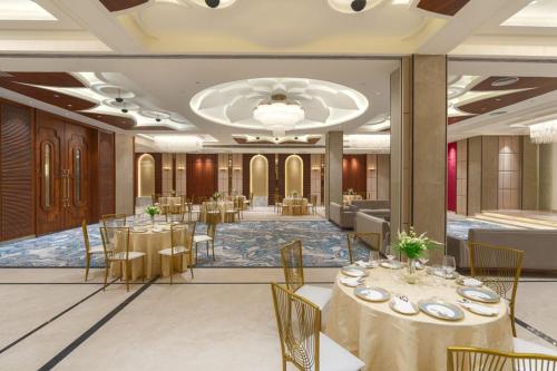 a banquet hall with tables and chairs in a room at AMBROSE Hotel in Mohali