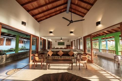 a living room with a ceiling fan and a table and chairs at Atulya Lake View Mirissa - Resort and Spa in Mirissa