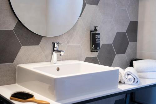 a white sink in a bathroom with a mirror at ibis Styles Strasbourg Nord Palais des Congrès in Schiltigheim