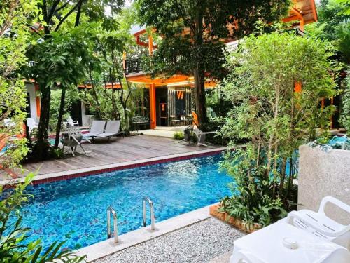 a swimming pool in front of a house at WOW PHUKET in Phuket Town