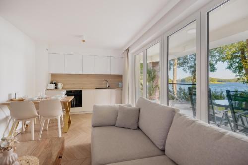 a living room with a couch and a kitchen with a table at Trzy Wyspy Barlinek in Barlinek