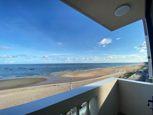 un apartamento en condominio con vistas a la playa desde el balcón en Hoàng Long Hotel, en Chợ Phước Hải