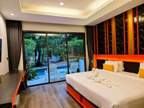 a bedroom with a bed and a view of a patio at WOW PHUKET in Phuket Town