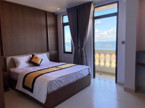 a bedroom with a bed with a view of the ocean at Hoàng Long Hotel in Chợ Phước Hải