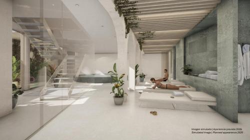 a woman sitting on a couch in a living room at Hotel Mercury by ALEGRIA in Santa Susanna