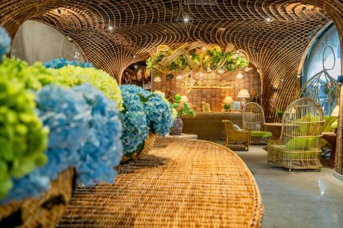 a room with wicker tables with blue flowers in it at The Signature Hotel Nha Trang in Nha Trang