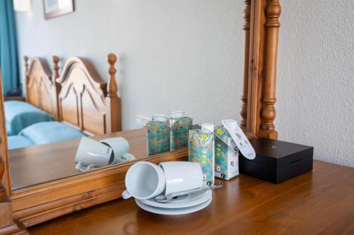 a table with a mirror and a plate and cups at Hotel Moon Dreams Mediterráneo in Torremolinos