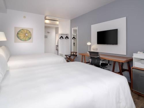 a hotel room with two beds and a desk at ANEW Hotel Roodepoort Johannesburg in Roodepoort