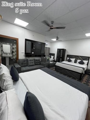 a living room with two beds and a tv at The Tulsi Garden - Ashram vihar vrindavan in Vrindāvan