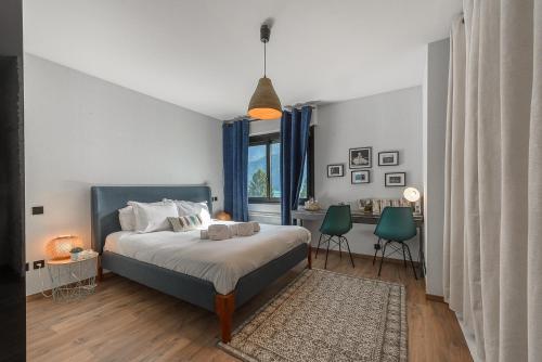 ein Schlafzimmer mit einem Bett und einem Tisch und Stühlen in der Unterkunft Le Cristal - Prestigieux appartement au Lac d'Annecy in Doussard