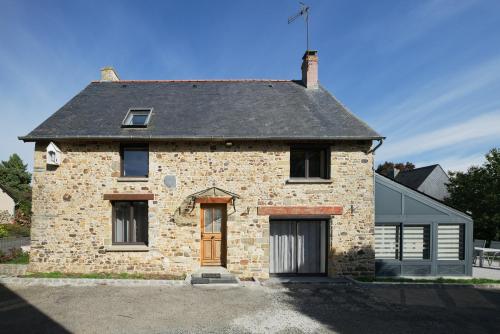 an old stone house with a black roof at Gite Cours Péan in Châteaugiron