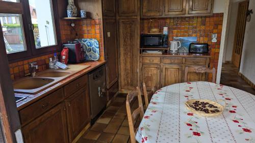 a small kitchen with a table and a sink at Villa Pierrette - Quiet house with garden in Saint-Jorioz