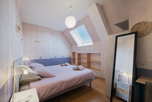 a bedroom with a bed with a window and a mirror at Gite Cours Péan in Châteaugiron