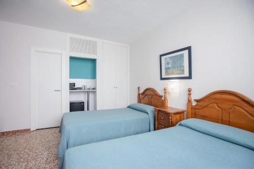 a bedroom with two beds with blue sheets at Hotel Moon Dreams Mediterráneo in Torremolinos