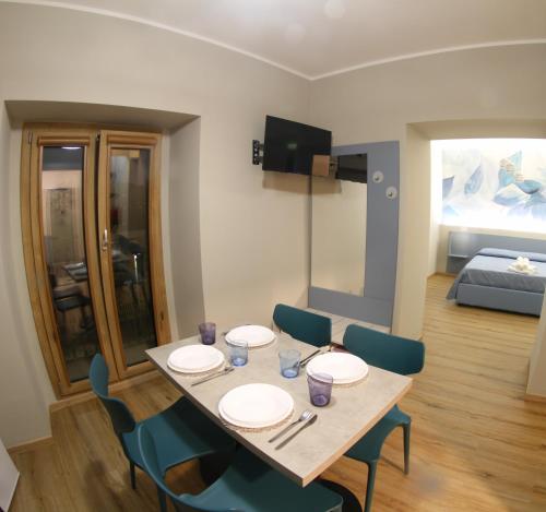 a dining room with a table and chairs and a bed at B&B La Colonna in Soveria Mannelli