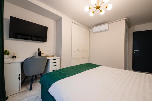 a bedroom with a bed and a desk and a tv at Thyon Residence in Alba Iulia