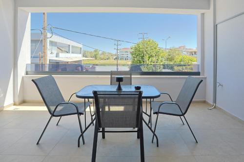 a table and chairs on a balcony with a window at Isol Rooms Β1 in Katerini