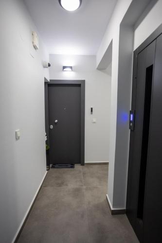 a hallway with a black door in a white room at Isol Rooms Β1 in Katerini