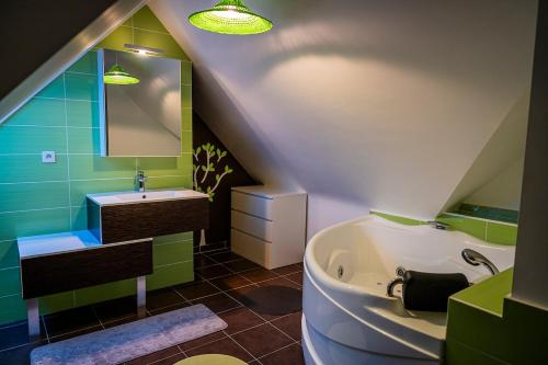 a attic bathroom with a tub and a sink at Magnifique villa vue mer ploumanac'h in Perros-Guirec
