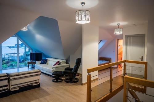 a living room with a couch and a chair at Magnifique villa vue mer ploumanac'h in Perros-Guirec