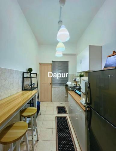 a kitchen with a black refrigerator and a counter at Eira Homestay Lost World Of Tambun M uslim only in Ipoh