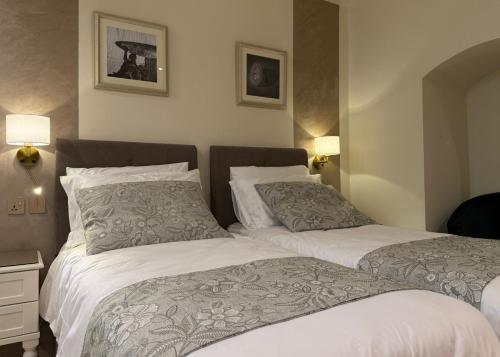two beds sitting next to each other in a bedroom at Sterling Luxury Suites Valletta in Valletta