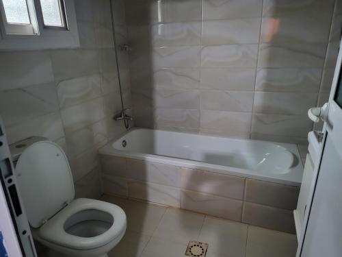 a bathroom with a white tub and a toilet at Tish home away from home in Safim