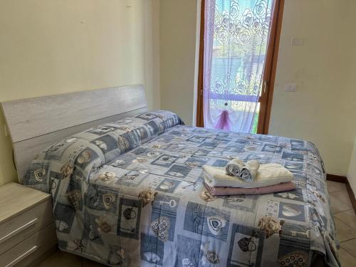 VobarnoにあるCasa favolosa sul Lago Di Gardaのベッドルーム1室(タオル付きのベッド1台、窓付)