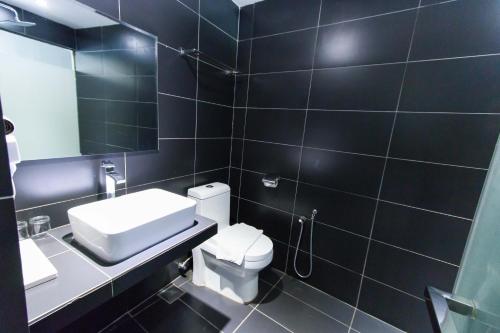 a bathroom with a toilet and a sink and a mirror at Hotel 99 Sri Petaling (Bukit Jalil) in Kuala Lumpur