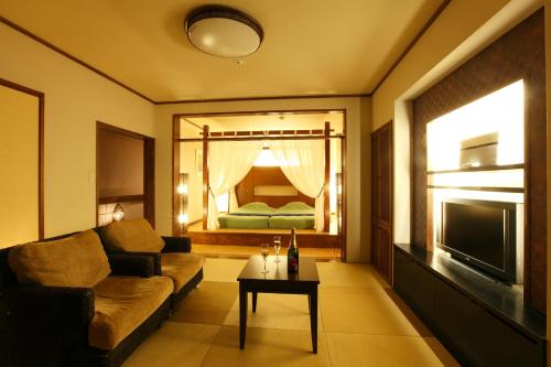 a living room with a couch and a television at Inatori Akao Hotel in Higashiizu