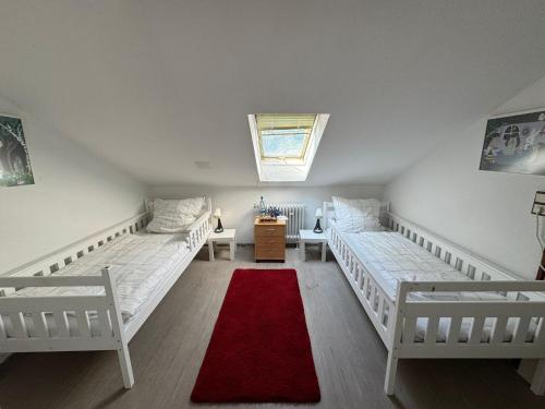 Zimmer mit 2 Betten und einem roten Teppich in der Unterkunft Helles Privatzimmer mit Gemeinschaftsküche und-bad in Hannover