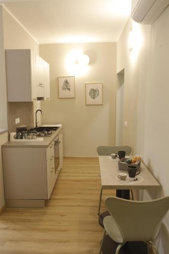 a kitchen with a stove and a table with chairs at B&B La Colonna in Soveria Mannelli