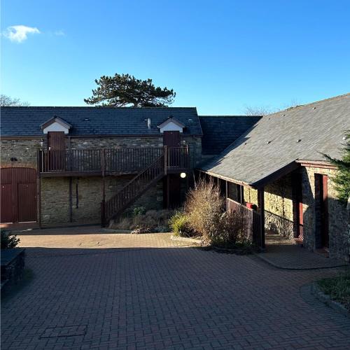 a large brick building with a deck and a staircase at The Gower Golf Club B&B in Gowerton