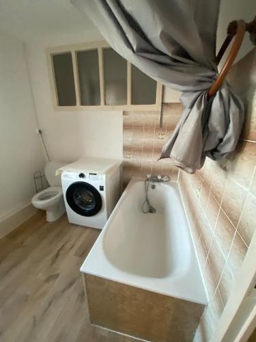 y baño con bañera y aseo. en Magnifique grand appartement dans le Morvan, en Château-Chinon