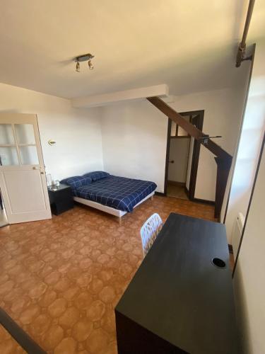 una sala de estar con una cama y una mesa en Magnifique grand appartement dans le Morvan, en Château-Chinon