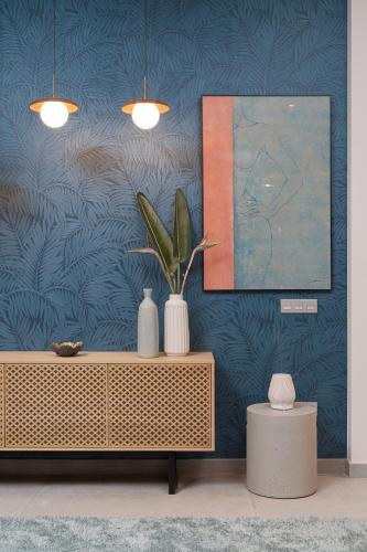 a living room with a cabinet with vases and a painting at Chez Abel in Las Palmas de Gran Canaria